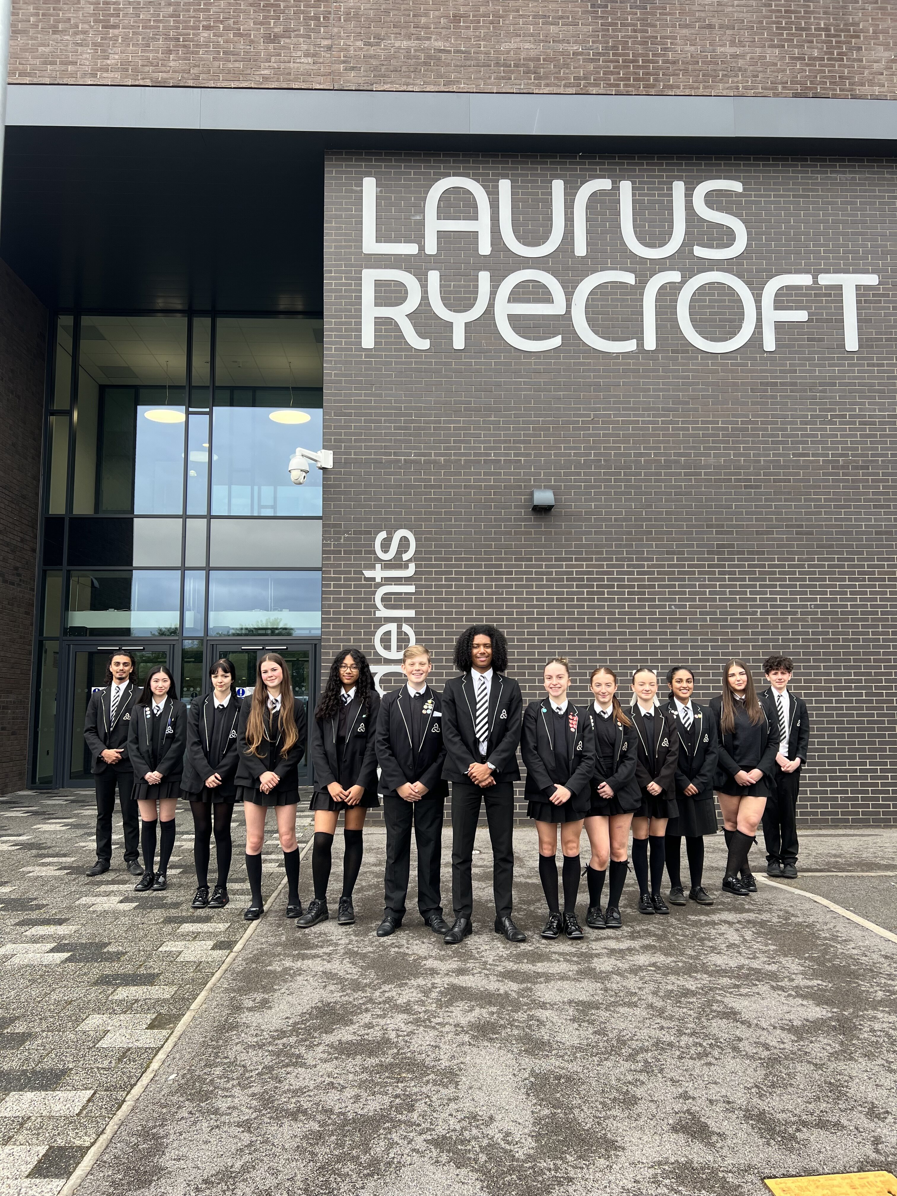 Laurus Ryecroft students stand in formation outside the school building