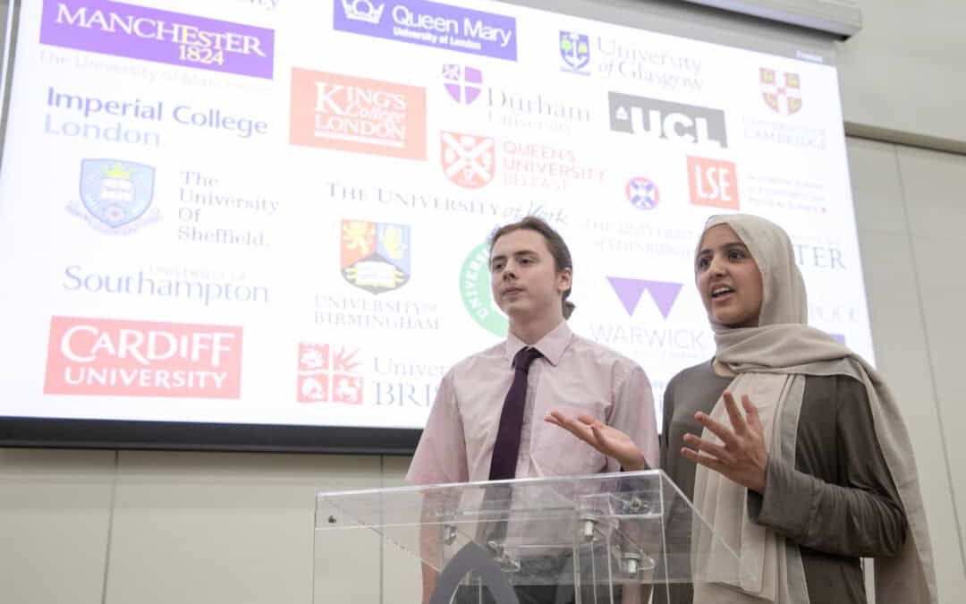 Laurus Ryecroft Sixth Form students speaking on the podium with a background of Russell Group universities.